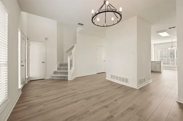 a view of a room with wooden floor and white walls