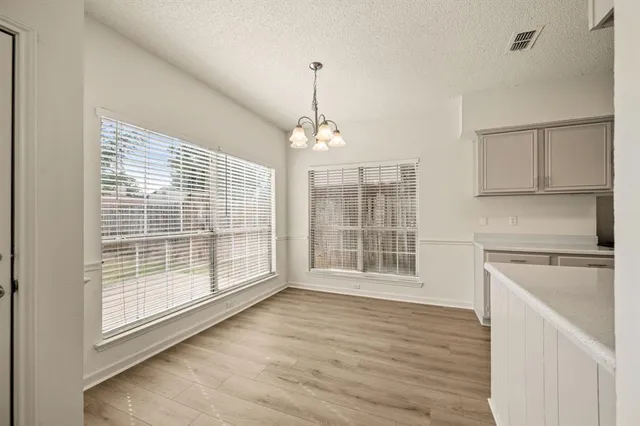 a view of wooden floor and kitchen in a room
