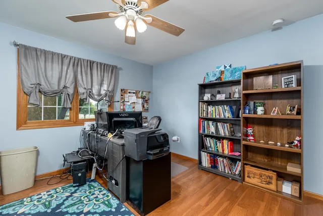 a view of a workspace with furniture and a bookshelf