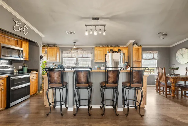 a kitchen with lots of white furniture appliances and a dining table