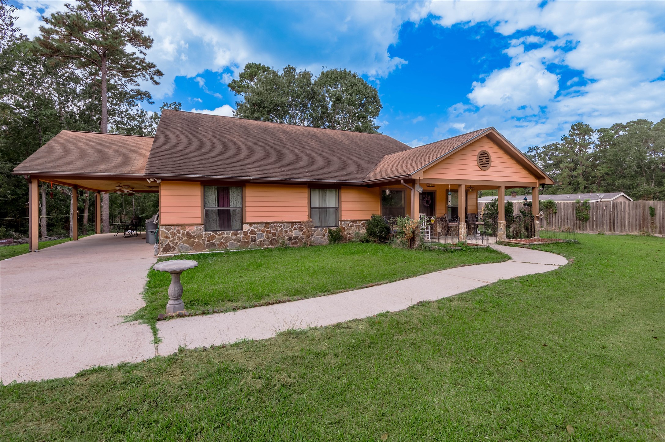47-57 Stage Coach Road Coldspring, TX 77331 - Photo 35 of 50 Charming single-story home with a warm, inviting exterior, featuring a spacious front porch and a large, well-maintained yard.