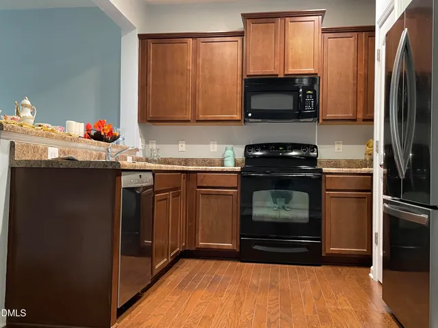 a kitchen with granite countertop a stove top oven and cabinets