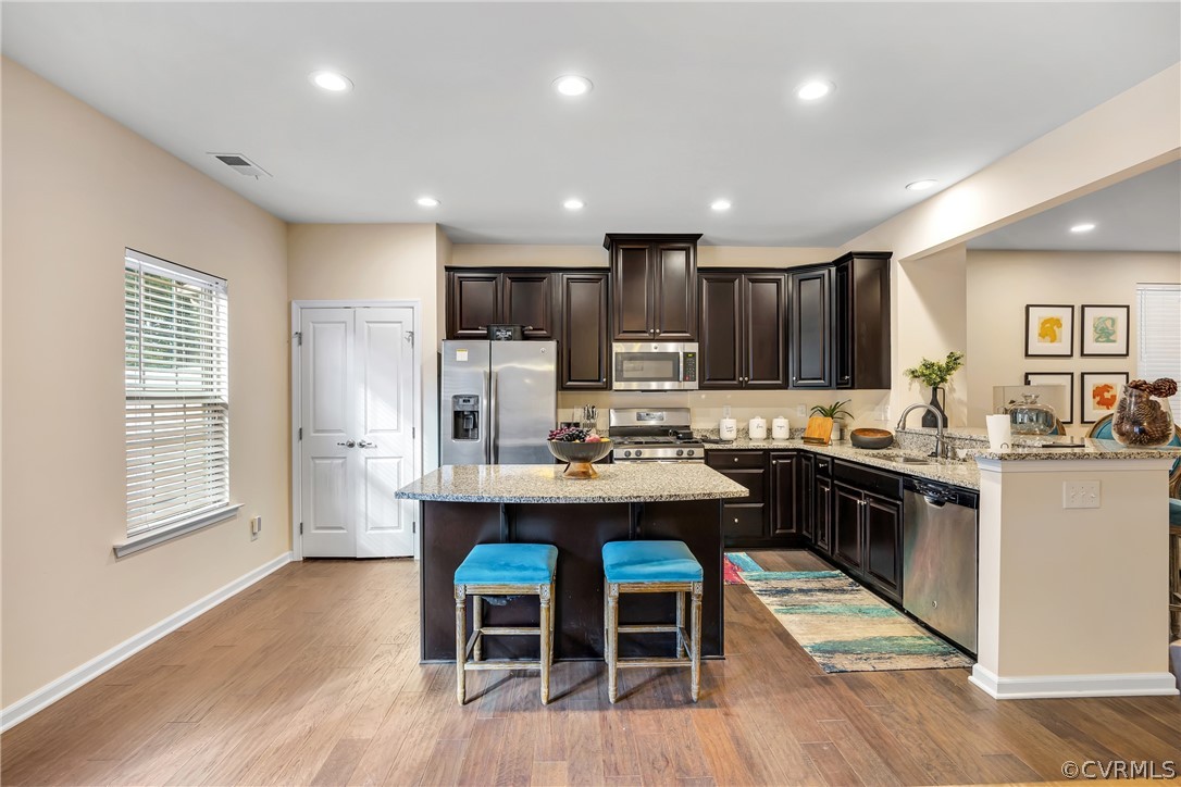 5724 Riverside Place Richmond, VA 23225 - Photo 12 of 47 a kitchen with stainless steel appliances kitchen island granite countertop a table chairs sink refrigerator and cabinets