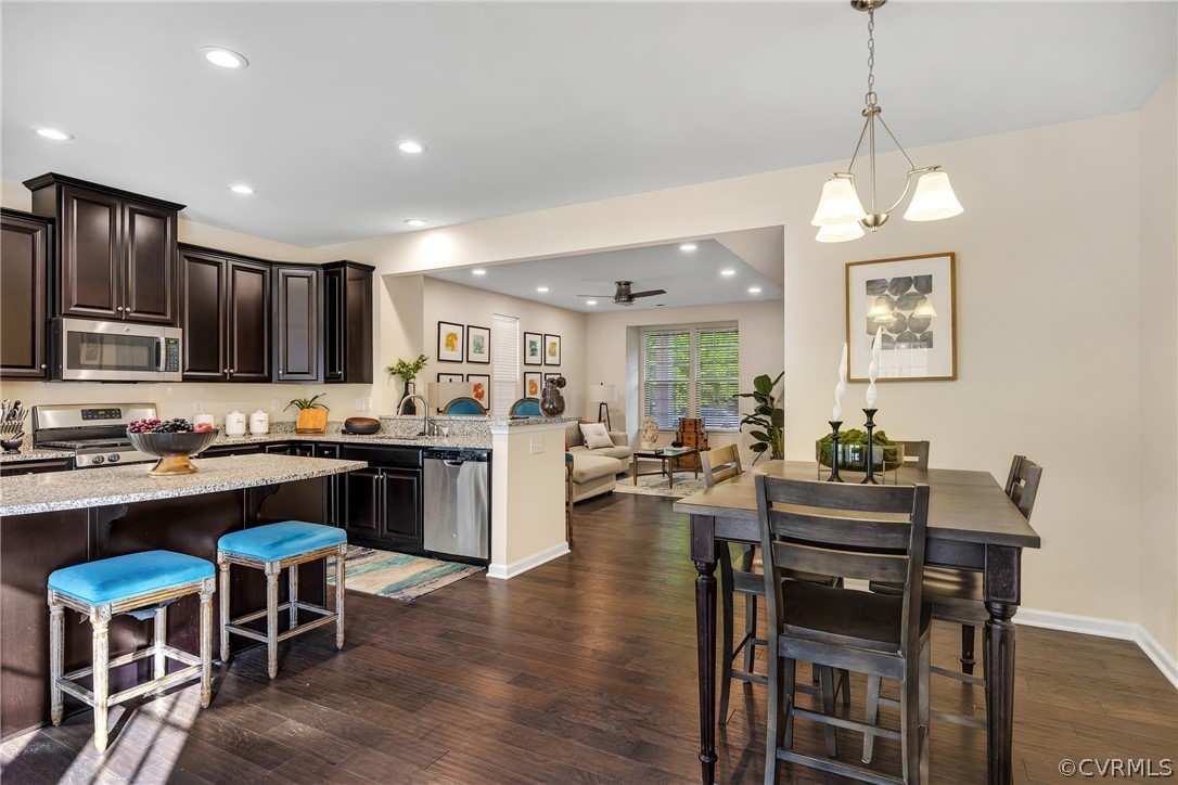 5724 Riverside Place Richmond, VA 23225 - Photo 18 of 47 a kitchen with stainless steel appliances granite countertop a stove top oven a refrigerator a sink dishwasher a dining table and chairs with wooden floor