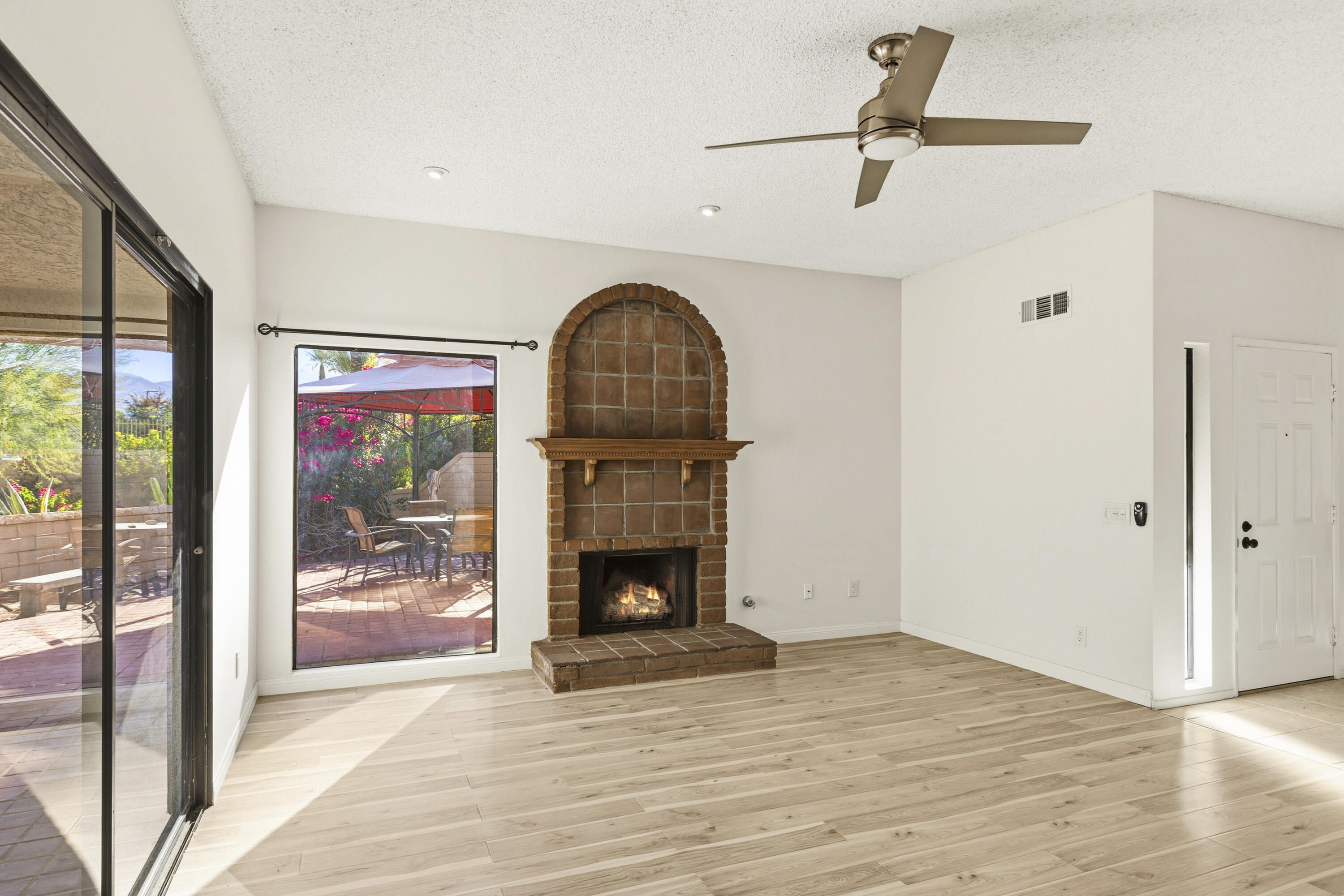 44695 Monaco Circle Palm Desert, CA 92260 - Photo 11 of 58 a view of an empty room with wooden floor fireplace and a window
