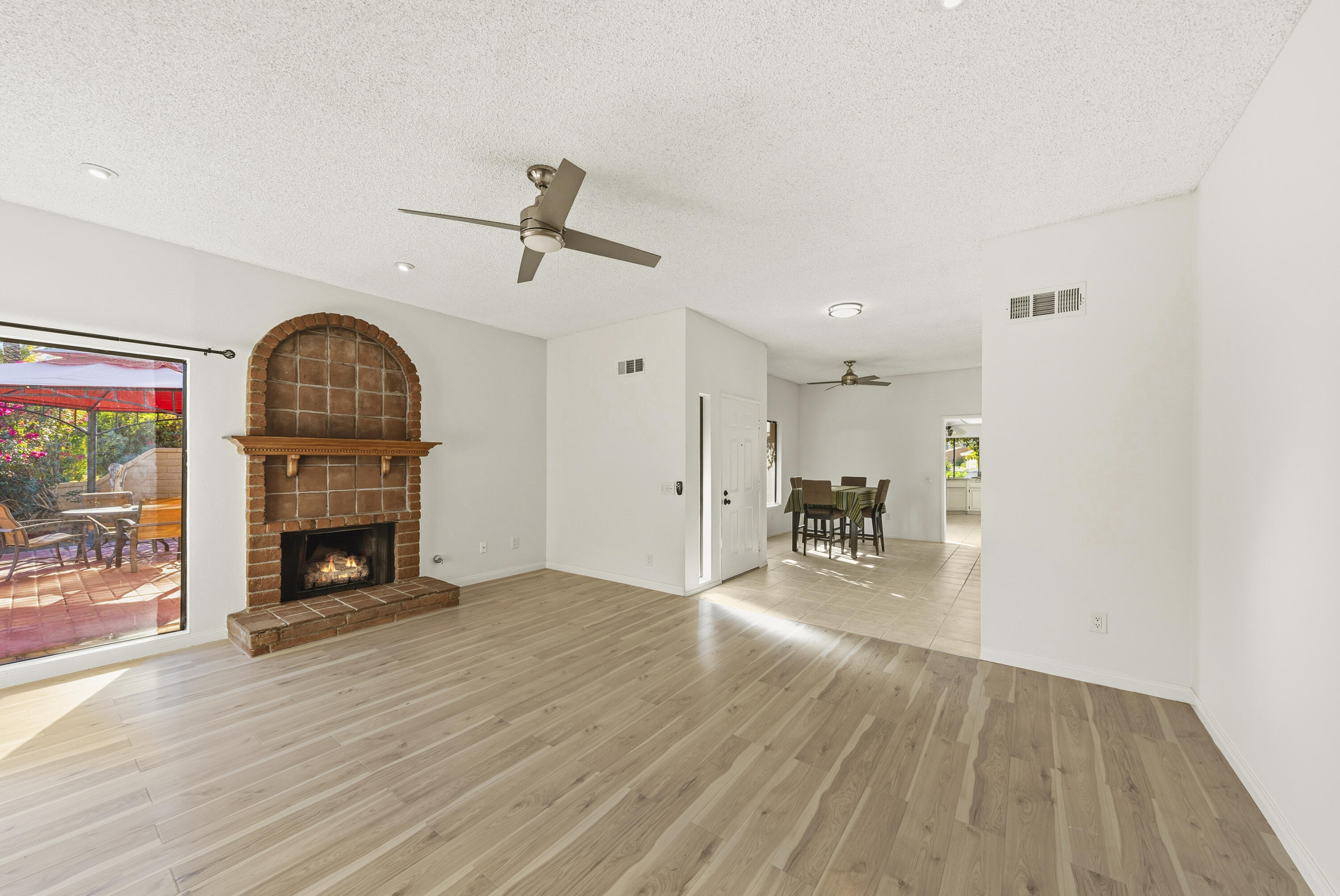 44695 Monaco Circle Palm Desert, CA 92260 - Photo 12 of 58 a view of an empty room with wooden floor fire place and a fireplace