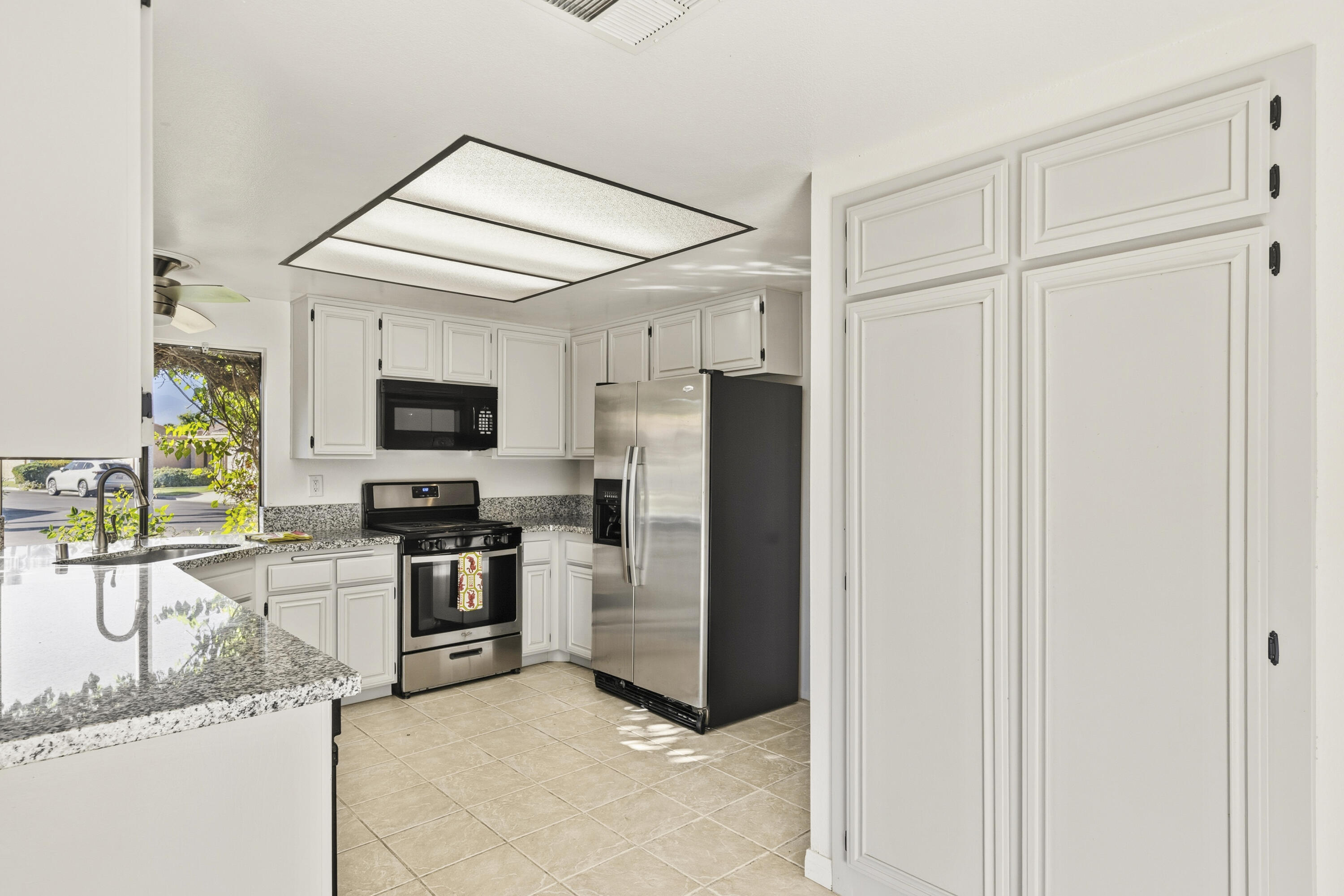 44695 Monaco Circle Palm Desert, CA 92260 - Photo 16 of 58 a kitchen with stainless steel appliances granite countertop a refrigerator and a stove top oven