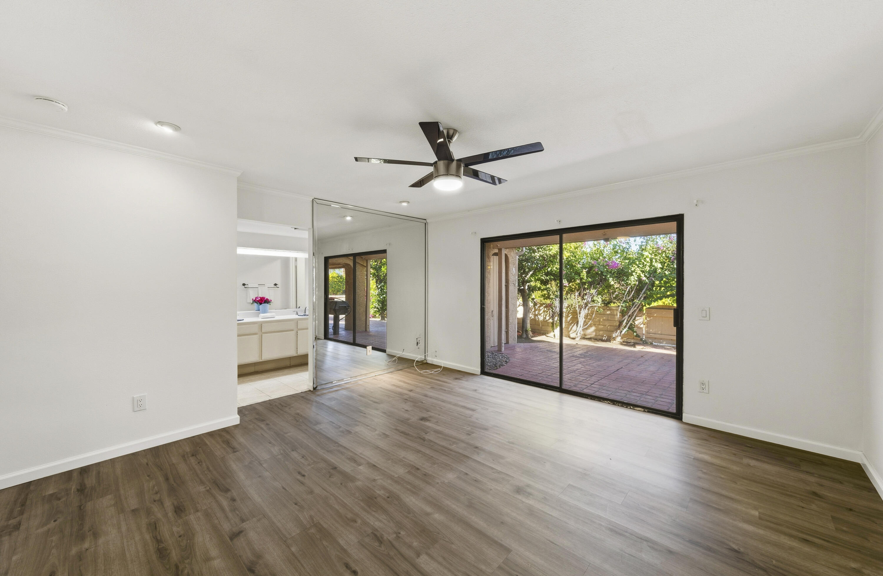44695 Monaco Circle Palm Desert, CA 92260 - Photo 20 of 58 an empty room with wooden floor and windows