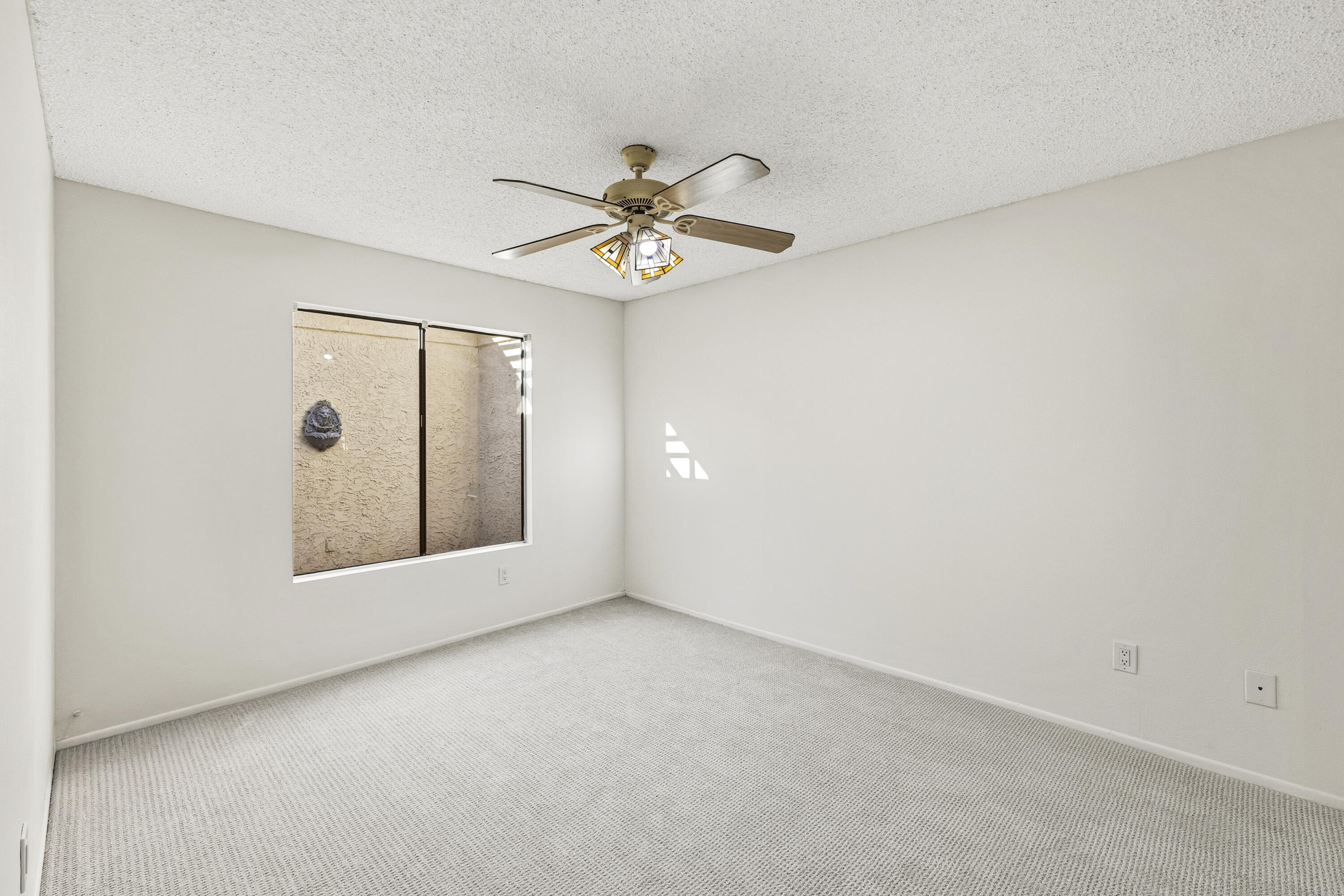 44695 Monaco Circle Palm Desert, CA 92260 - Photo 24 of 58 an empty room with chandelier fan and windows