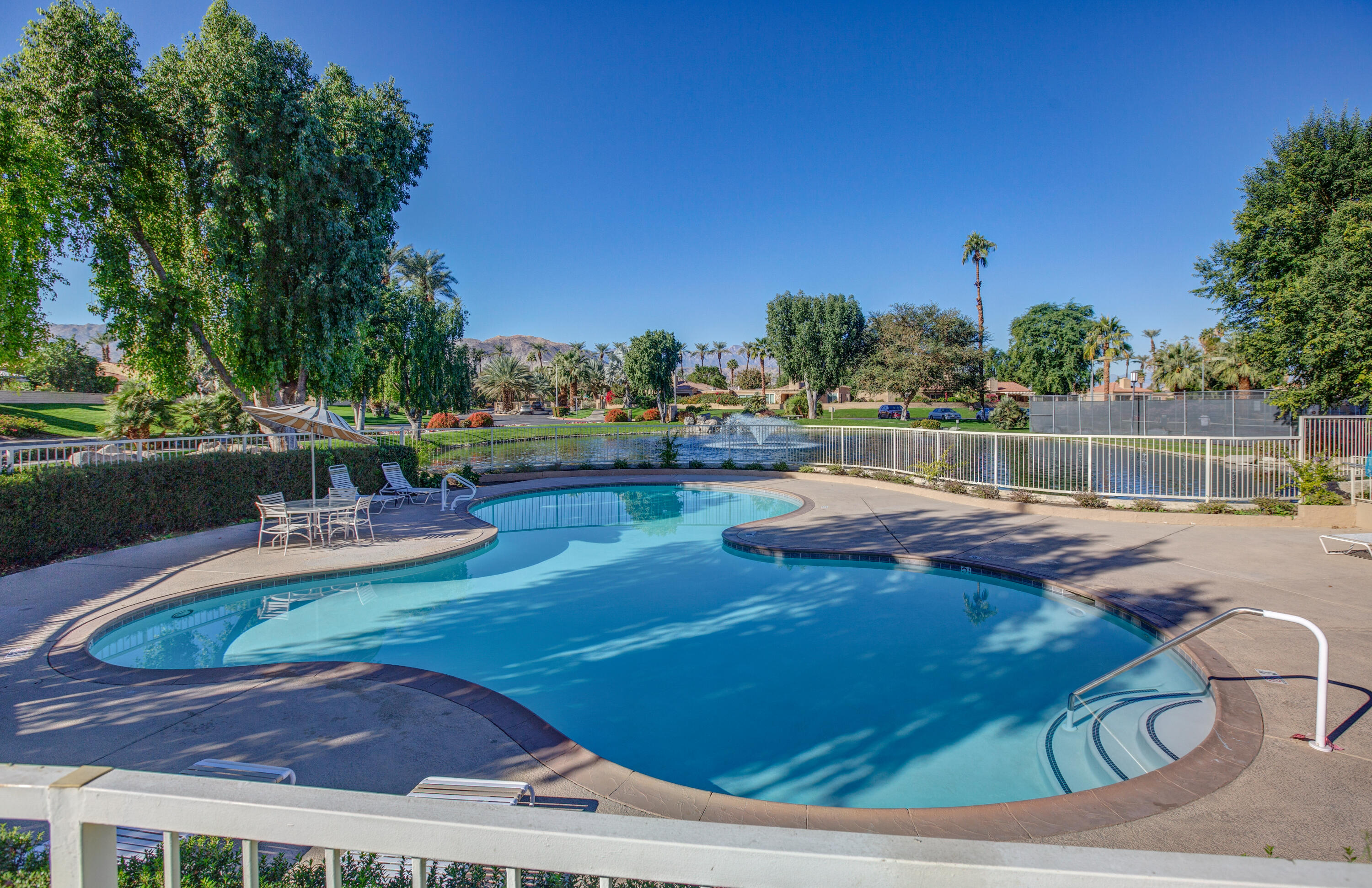 44695 Monaco Circle Palm Desert, CA 92260 - Photo 56 of 58 a view of a swimming pool with lounge chairs