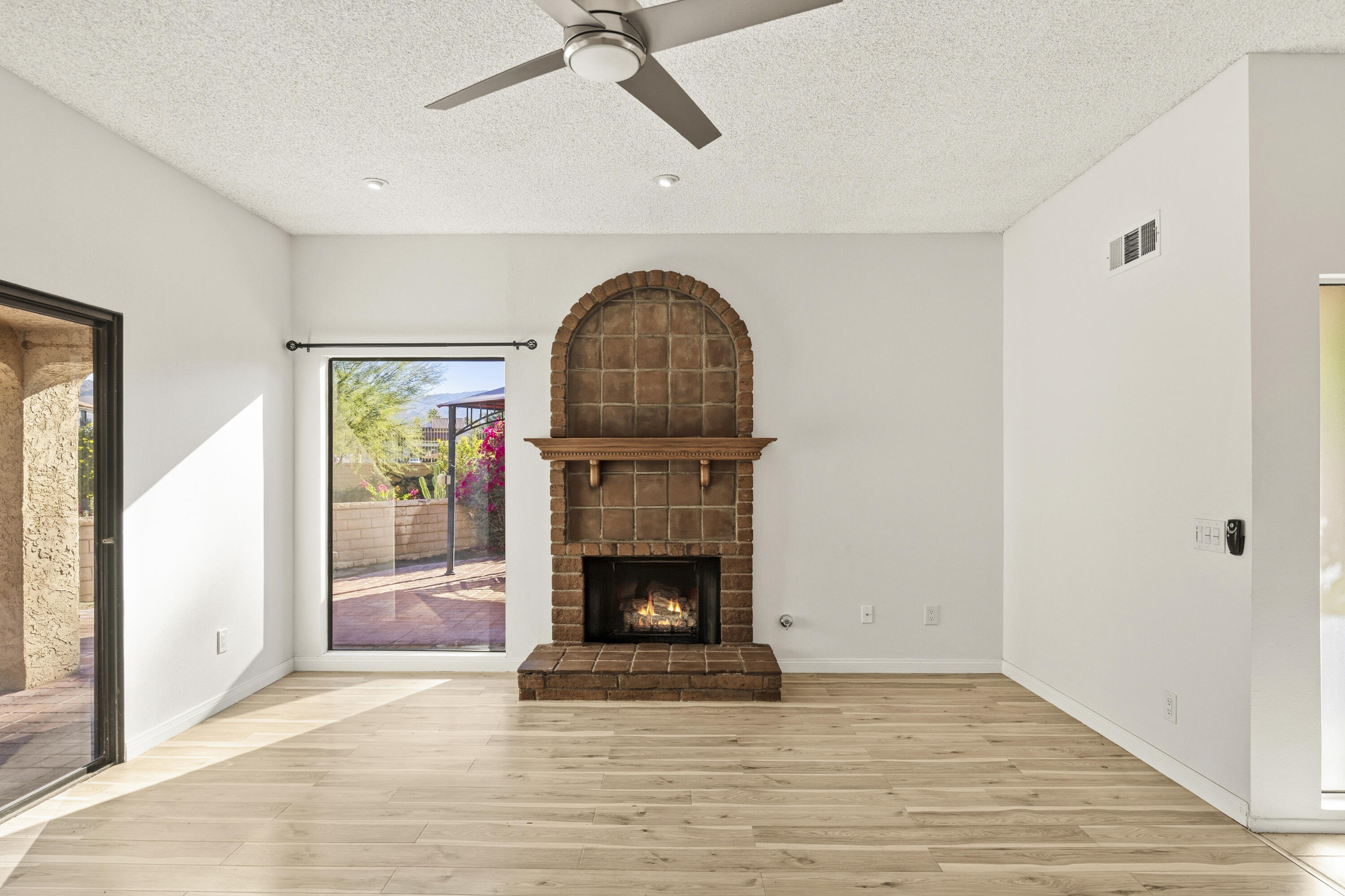 44695 Monaco Circle Palm Desert, CA 92260 - Photo 10 of 58 a view of an empty room with wooden floor and a fireplace