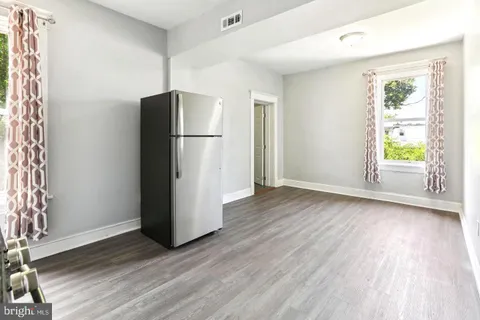 a view of a kitchen with wooden floor and a refrigerator