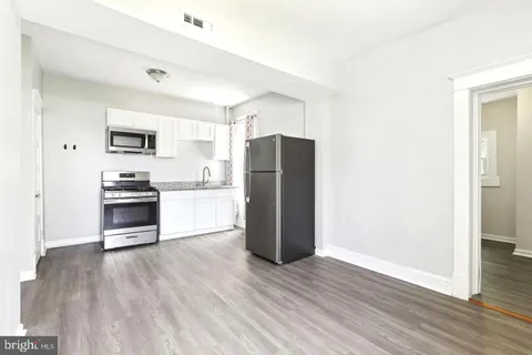 a kitchen with a refrigerator and a stove top oven