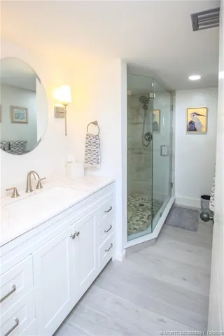 a spacious bathroom with a shower sink and mirror