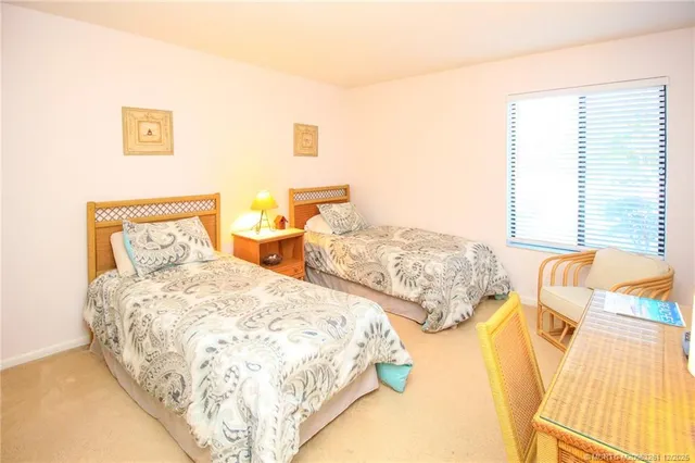 a bedroom with two beds and a lamp