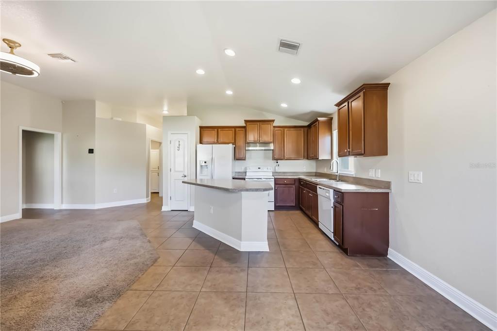 9984 Spring Gulch Lane Punta Gorda, FL 33950 - Photo 13 of 31 a large kitchen with stainless steel appliances granite countertop a large counter top a stove a sink and a refrigerator