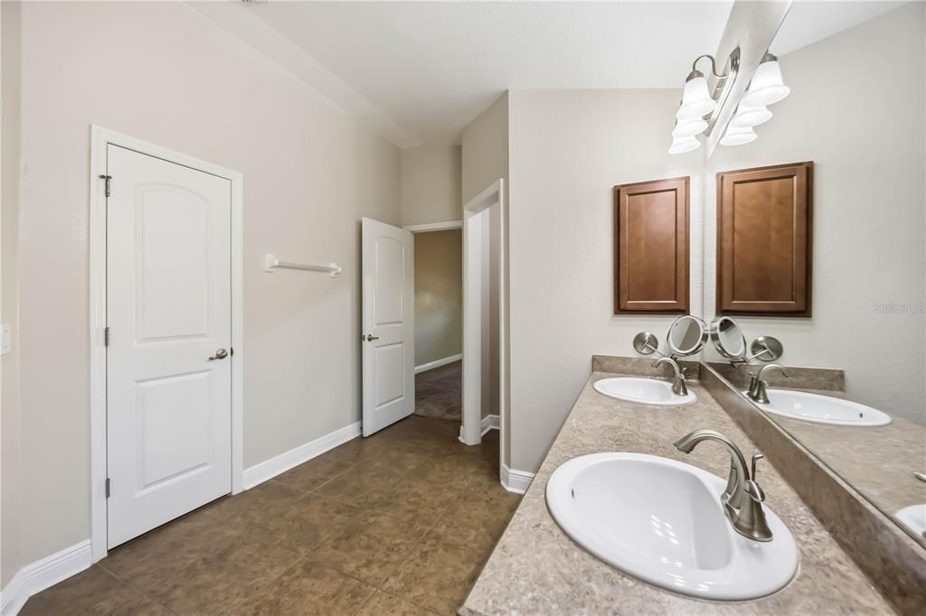 9984 Spring Gulch Lane Punta Gorda, FL 33950 - Photo 27 of 31 a en suite bathroom with a granite countertop double vanity and a mirror