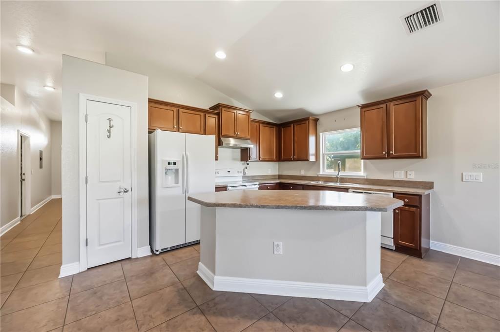 9984 Spring Gulch Lane Punta Gorda, FL 33950 - Photo 9 of 31 a kitchen with stainless steel appliances granite countertop a stove top oven a sink and a refrigerator