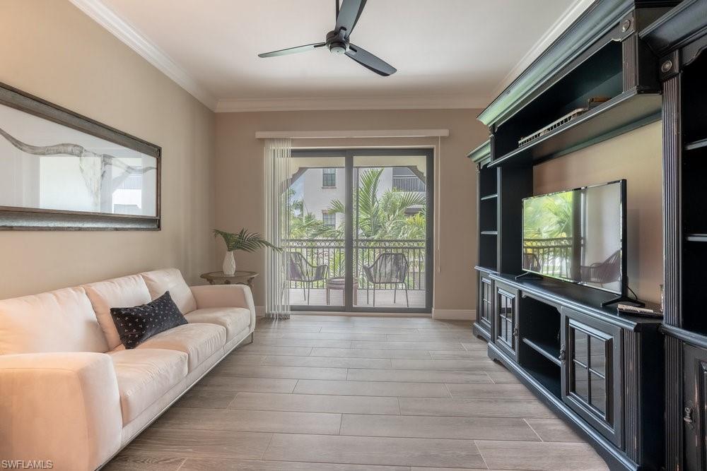 16375 Viansa Way, Unit 102 Naples, FL 34110 - Photo 14 of 40 a living room with furniture tv and a large window