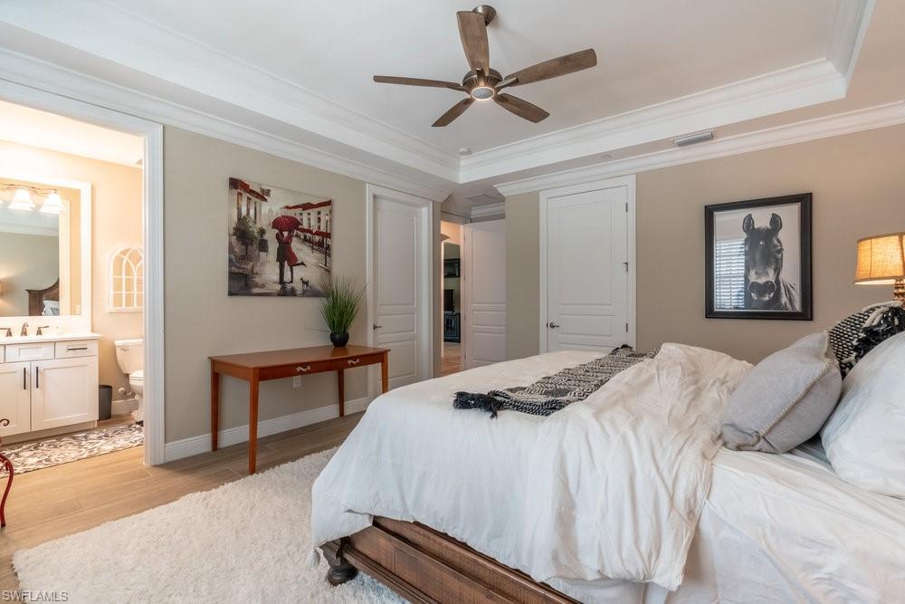 16375 Viansa Way, Unit 102 Naples, FL 34110 - Photo 16 of 40 a bedroom with a bed and a chandelier