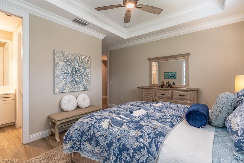 16375 Viansa Way, Unit 102 Naples, FL 34110 - Photo 19 of 40 a bedroom with a large bed and a chandelier