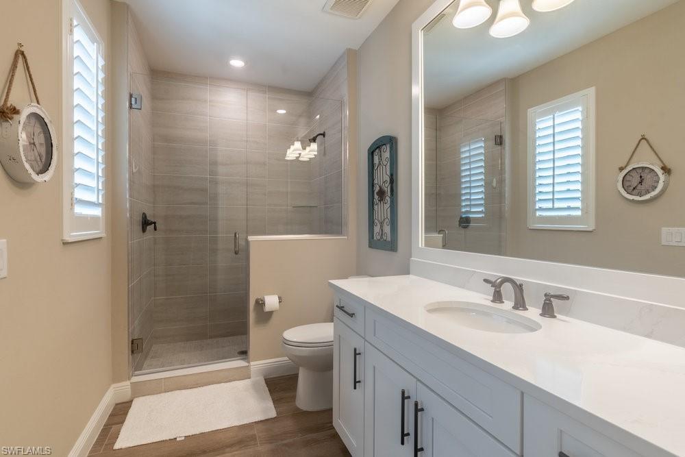 16375 Viansa Way, Unit 102 Naples, FL 34110 - Photo 20 of 40 a bathroom with a granite countertop sink toilet and shower