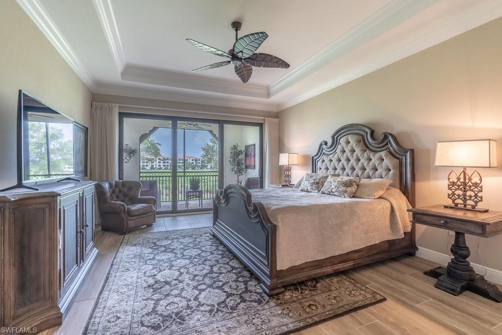 16375 Viansa Way, Unit 102 Naples, FL 34110 - Photo 21 of 40 a bedroom with a large bed and a chandelier