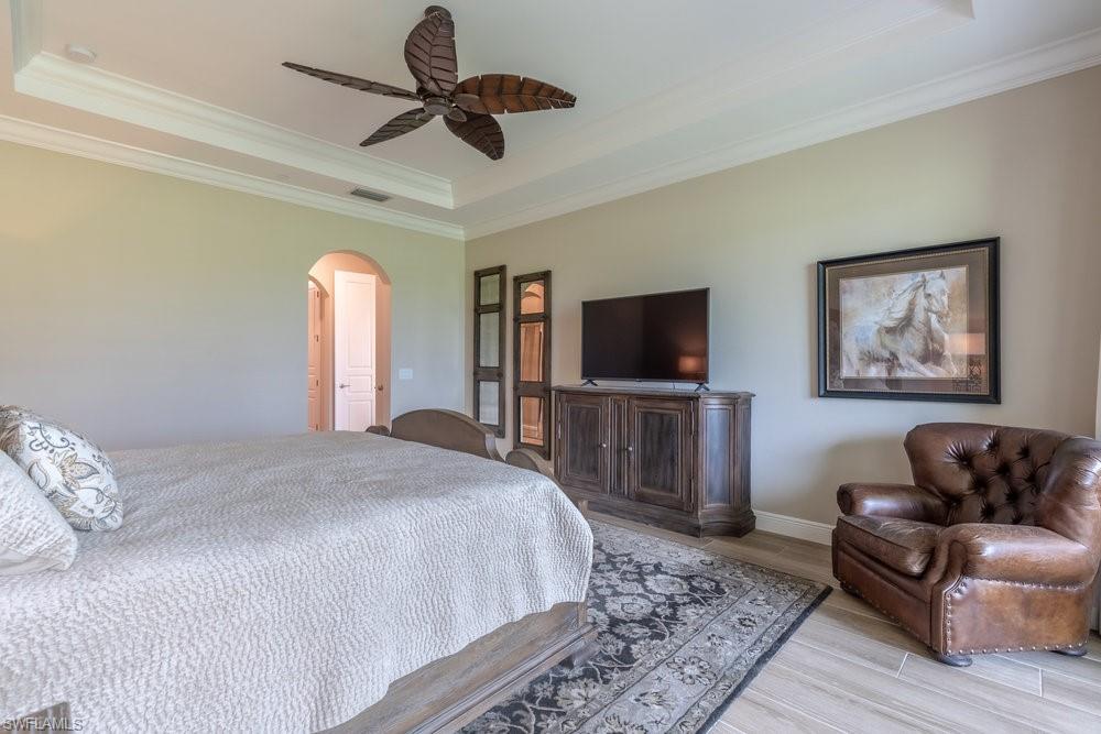 16375 Viansa Way, Unit 102 Naples, FL 34110 - Photo 22 of 40 a bedroom with a bed and a flat screen tv