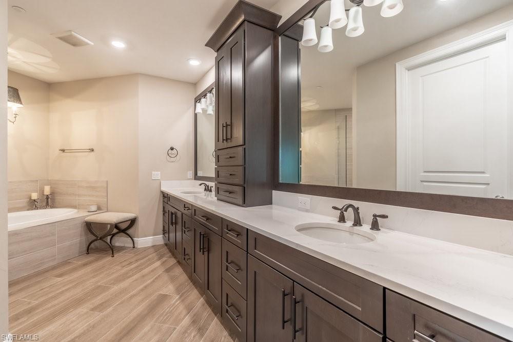 16375 Viansa Way, Unit 102 Naples, FL 34110 - Photo 23 of 40 a spacious bathroom with a double vanity sink mirror and double