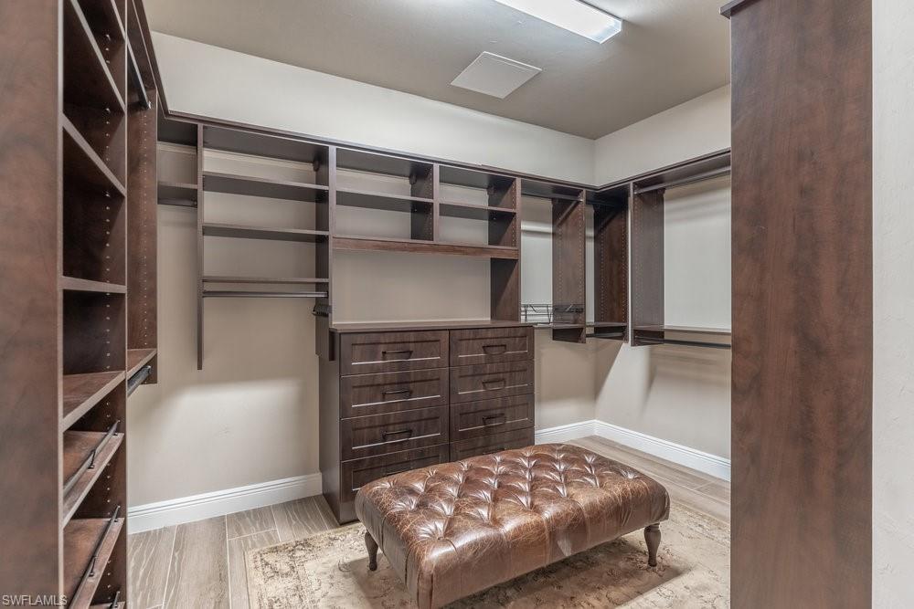 16375 Viansa Way, Unit 102 Naples, FL 34110 - Photo 25 of 40 a view of walk in closet with clothes and shoes