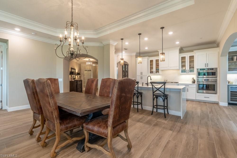 16375 Viansa Way, Unit 102 Naples, FL 34110 - Photo 5 of 40 a view of a dining room with furniture and wooden floor