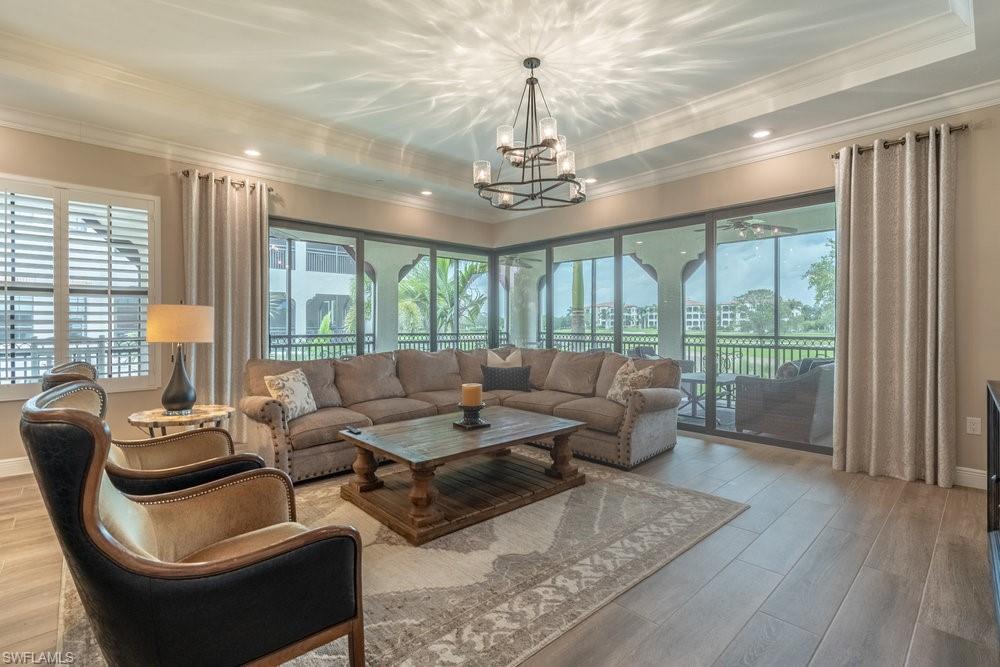 16375 Viansa Way, Unit 102 Naples, FL 34110 - Photo 6 of 40 a living room with furniture and a chandelier