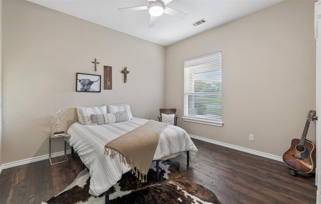 492 County Road 4387 Decatur, TX 76234 - Photo 19 of 40 a bedroom with a bed and a chandelier