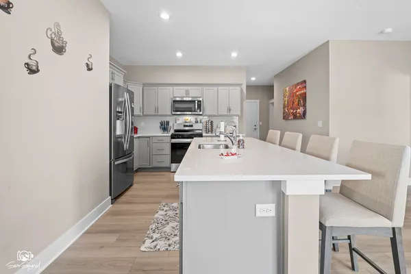 a kitchen with kitchen island a appliances a sink and a refrigerator