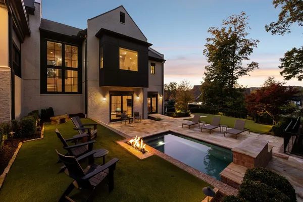 a view of a swimming pool with chairs and a yard