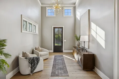a living room with furniture and a chandelier