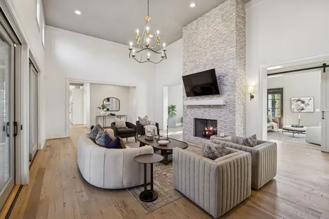 a kitchen with stainless steel appliances granite countertop a stove a sink dishwasher a refrigerator and white cabinets with wooden floor