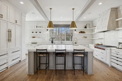 a kitchen with stainless steel appliances cabinets and a wooden floor