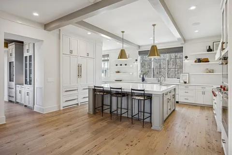 a view of a hallway with wooden floor and windows