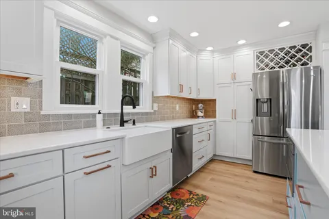 a kitchen with white cabinets and stainless steel appliances