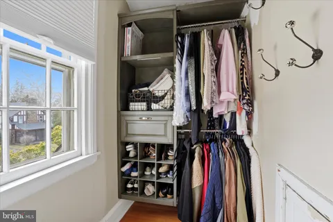 a view of walk in closet with clothes and shoes