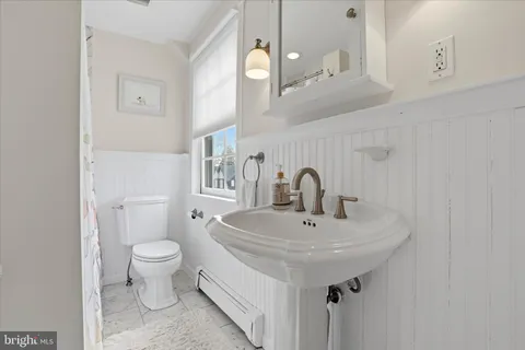 a bathroom with a sink a toilet and a mirror