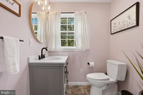 a bathroom with a toilet sink and mirror