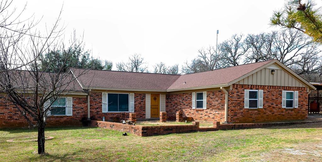 285 Montgomery Road Mineral Wells, TX 76067 - Photo 1 of 26 a front view of a house with a yard table and chairs