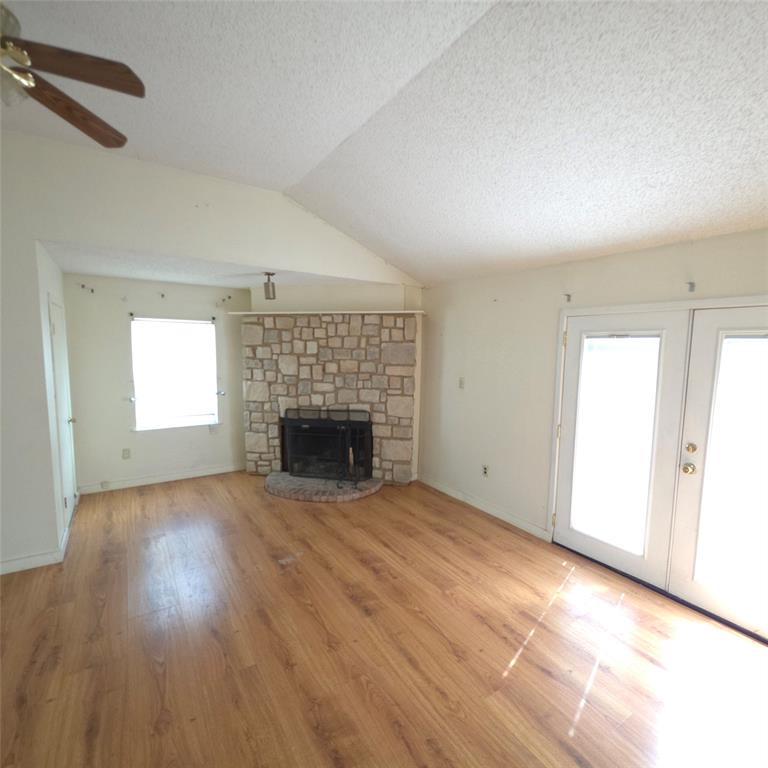 285 Montgomery Road Mineral Wells, TX 76067 - Photo 13 of 26 an empty room with wooden floor fireplace and windows