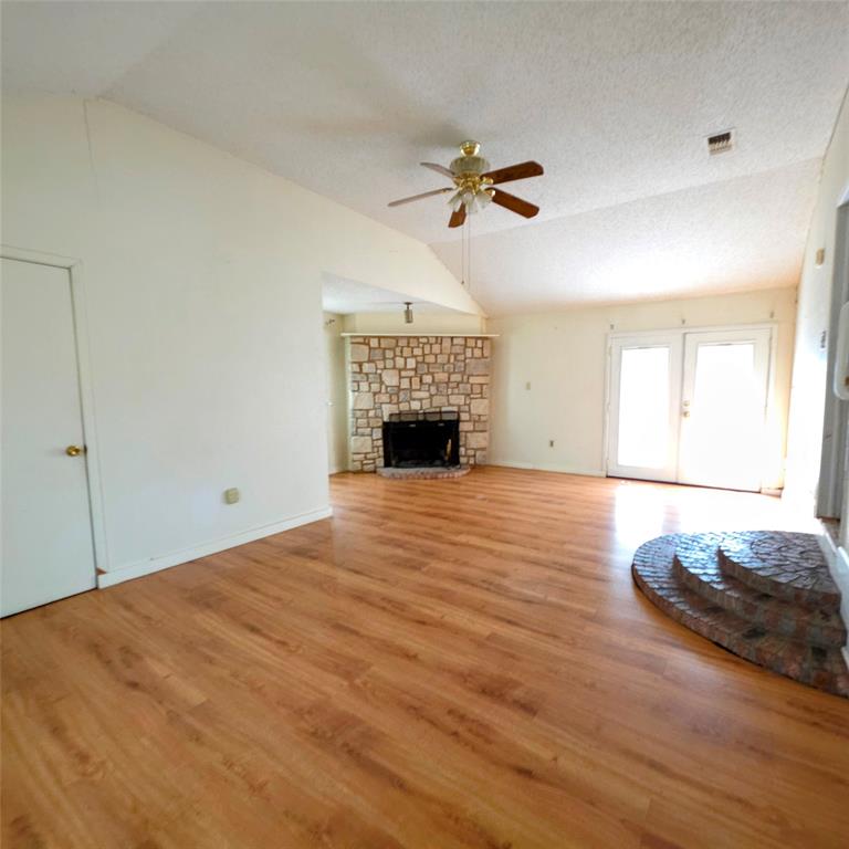 285 Montgomery Road Mineral Wells, TX 76067 - Photo 14 of 26 a big room with wooden floor fireplace and windows
