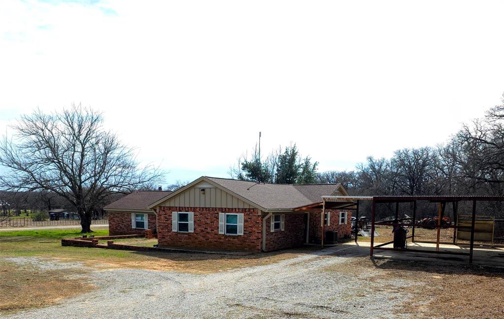 285 Montgomery Road Mineral Wells, TX 76067 - Photo 3 of 26 a view of a house with wooden fence next to a yard