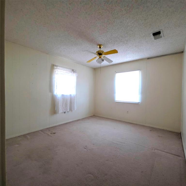 285 Montgomery Road Mineral Wells, TX 76067 - Photo 6 of 26 an empty room with windows and chandelier fan