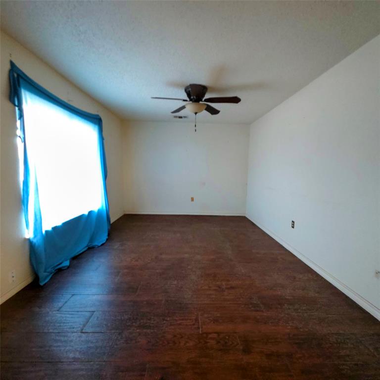 285 Montgomery Road Mineral Wells, TX 76067 - Photo 9 of 26 an empty room with wooden floor and windows