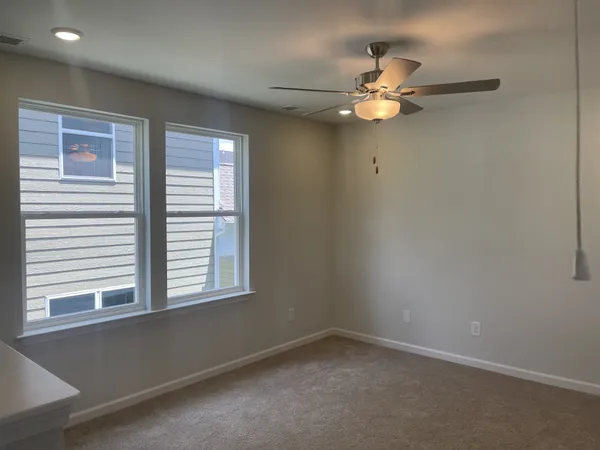 a view of a livingroom with a ceiling fan and window